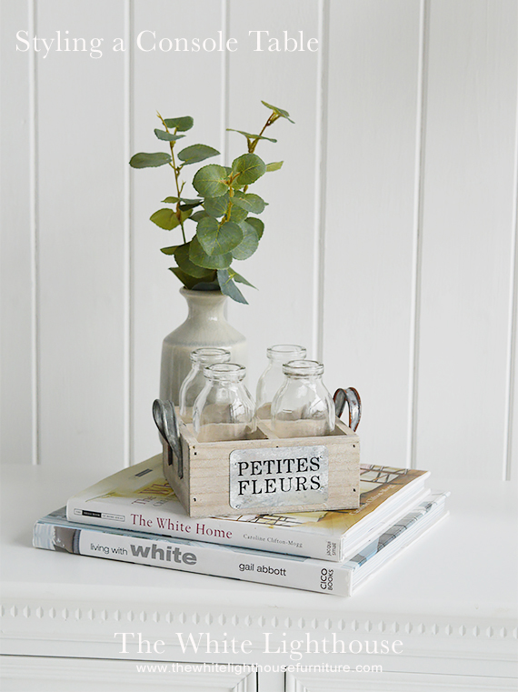 Coffee table books offer a creative display on your console table