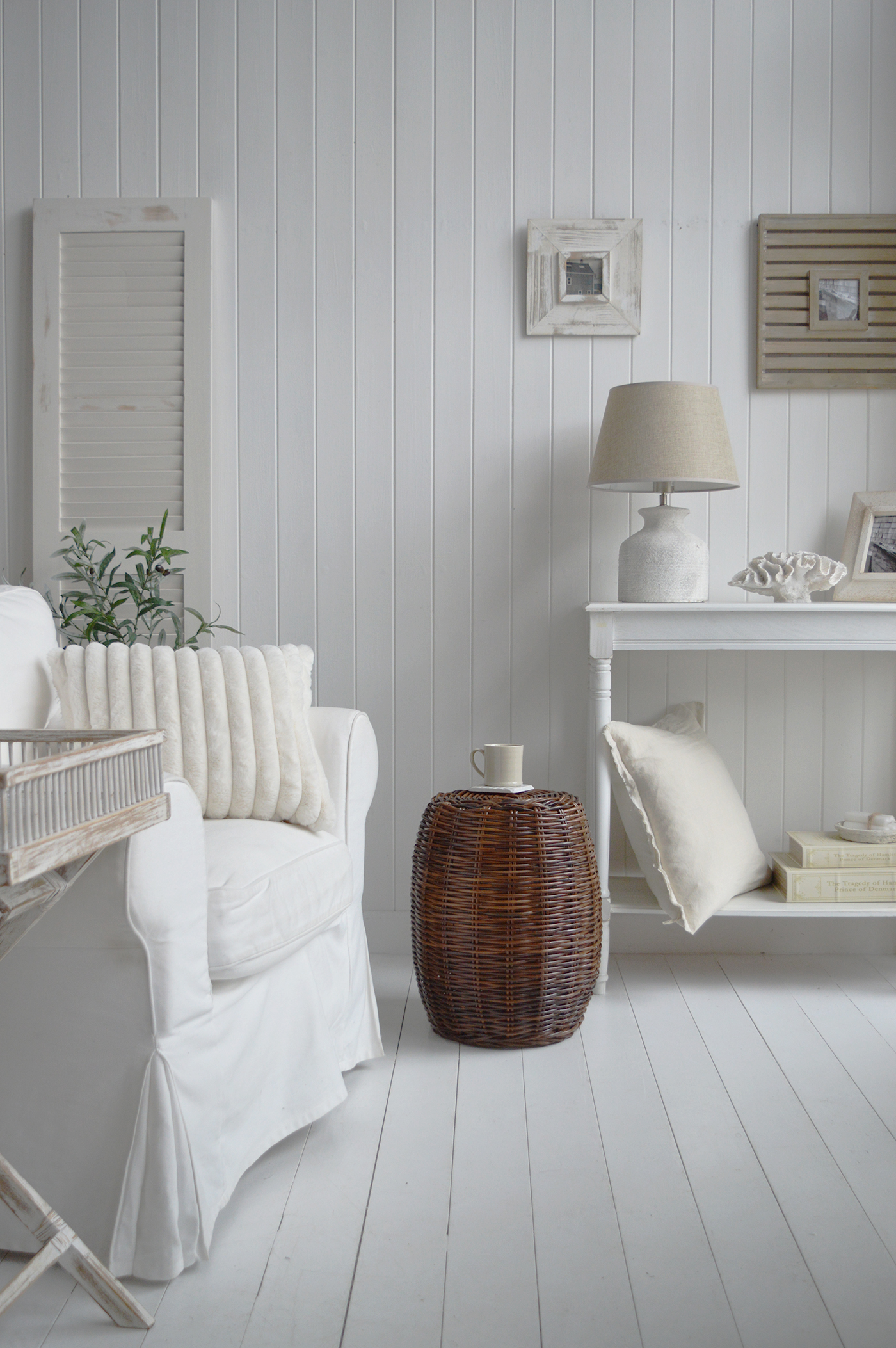 The Cove bay rattan stool as a side table, shown with a coaster and cup in this beach house style coastal setting