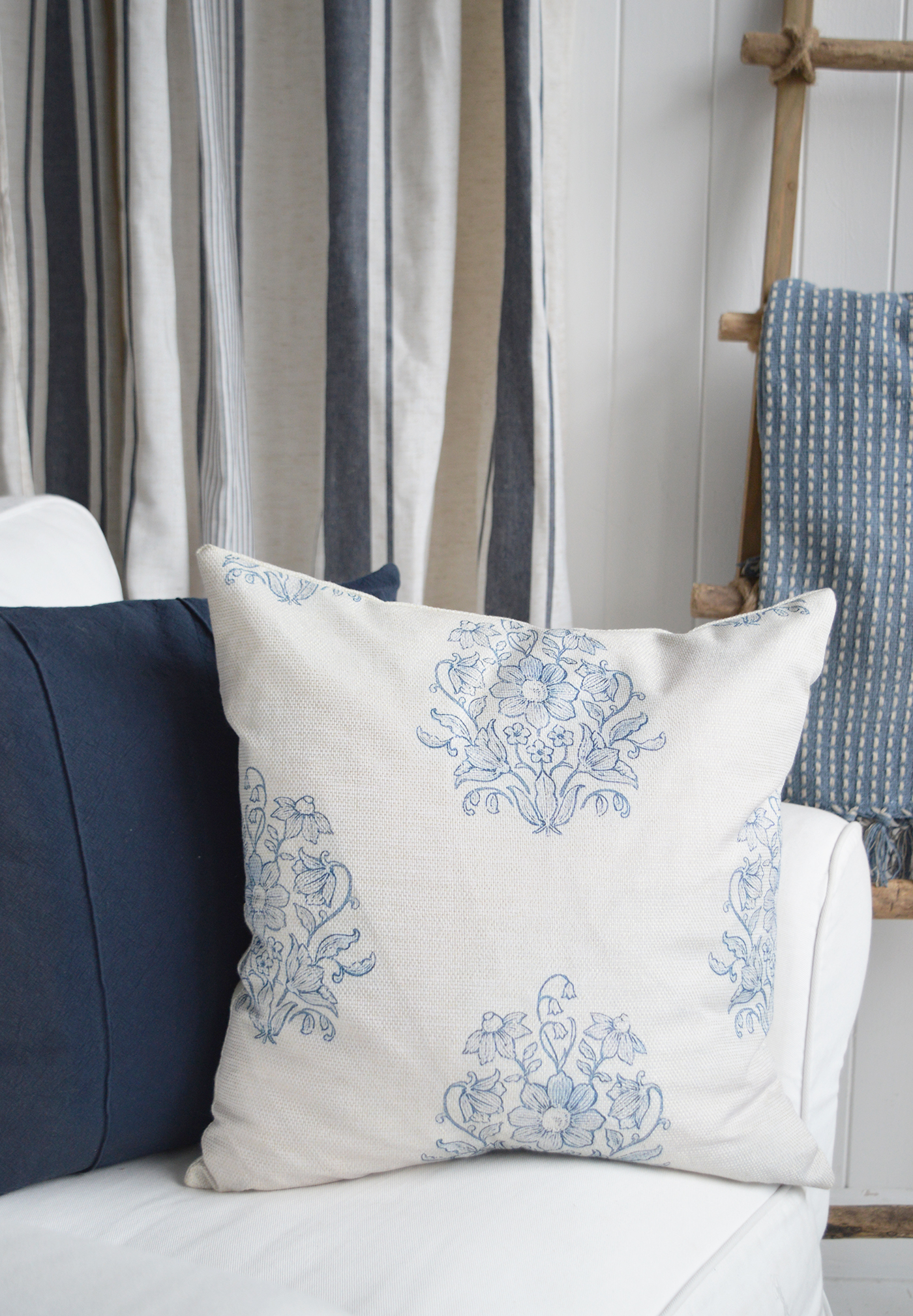 Blue cushions and white furniture create a fresh, welcoming New England-style living room.