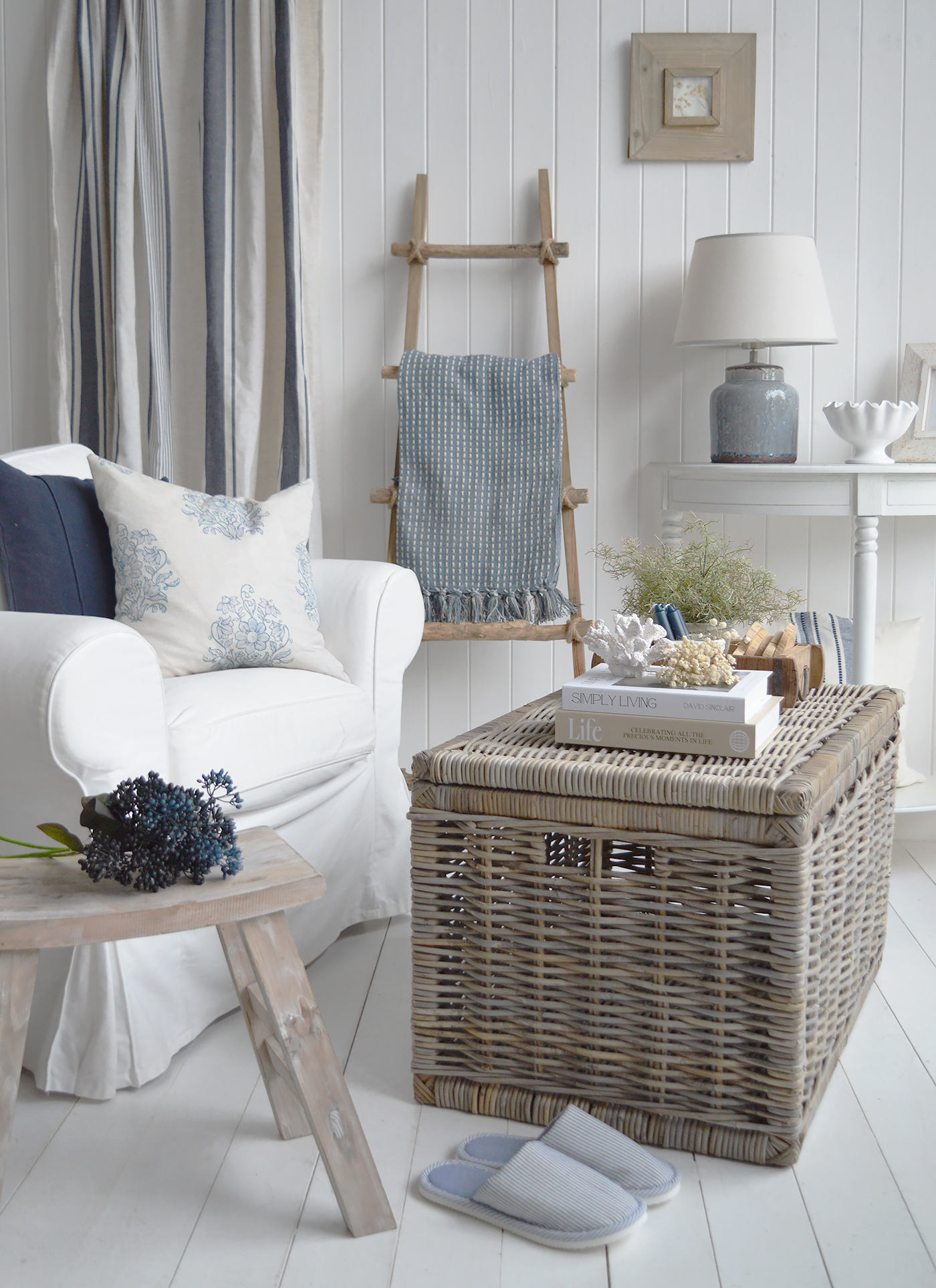 A blue lamp and striped cushion give the white console table a coastal feel.