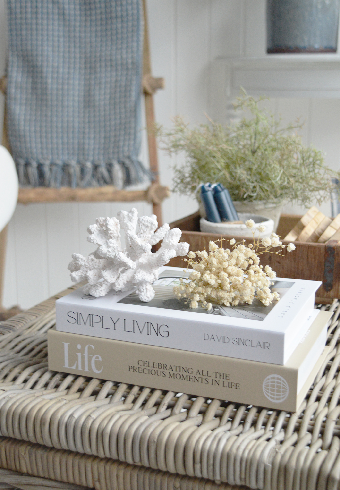 A woven coffee table adds natural texture and warmth to the blue and white scheme.