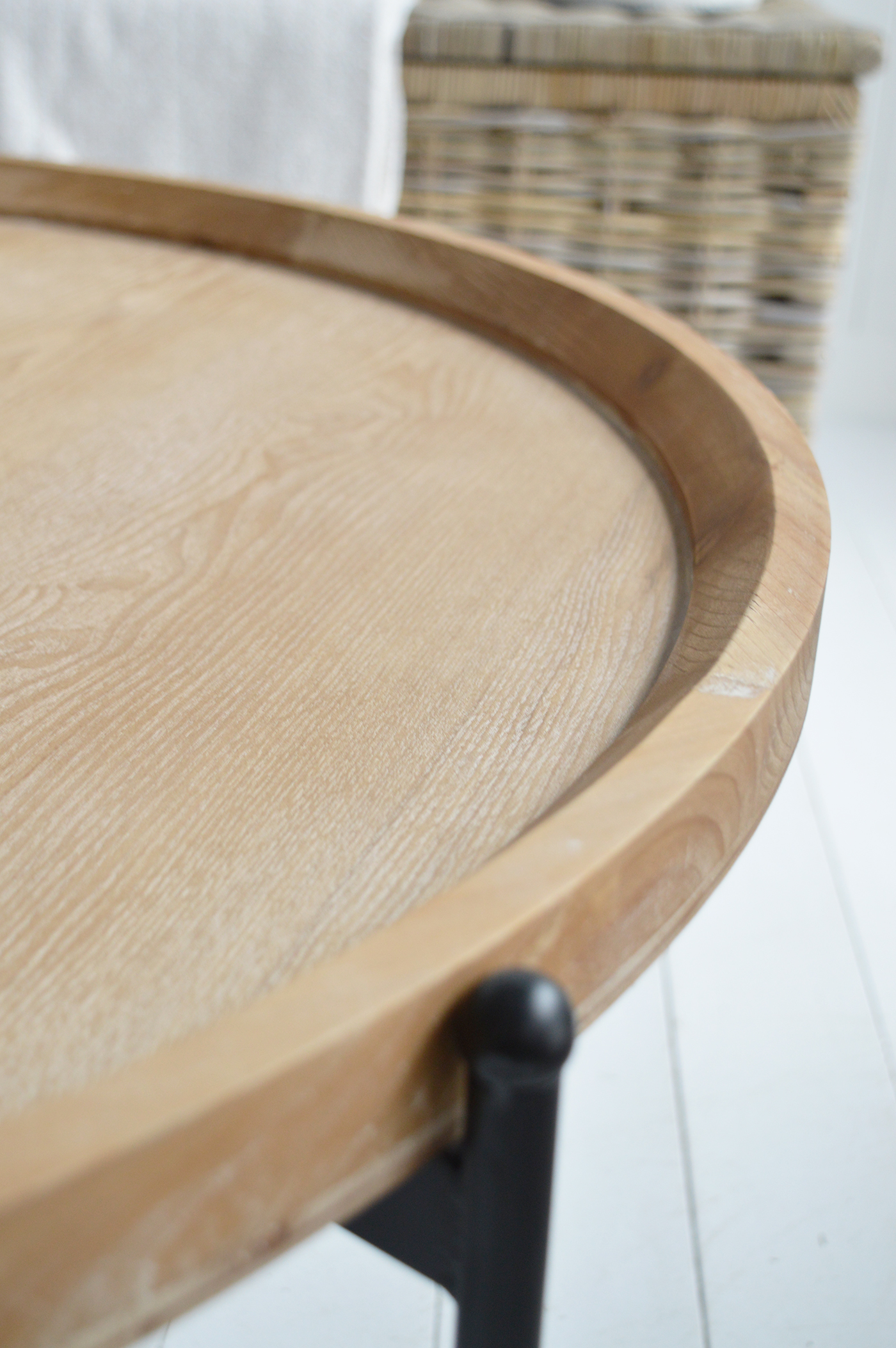 The distressed whitewashed wood top evokes the breezy, sun-kissed charm of coastal New England, while the contrasting black legs add a touch of modern elegance.
