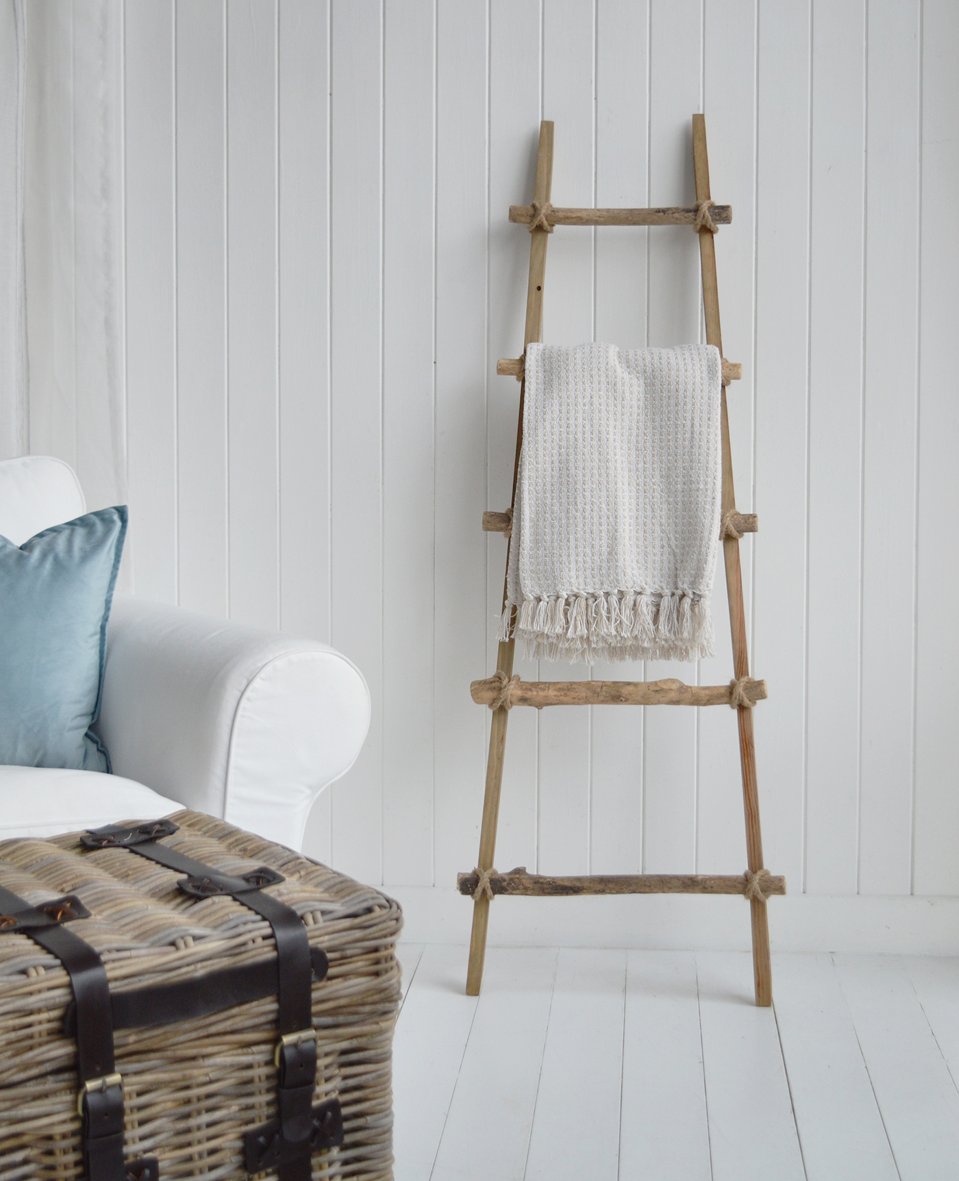 The driftwood wooden ladder brings natural texture to a modern coastal living room.