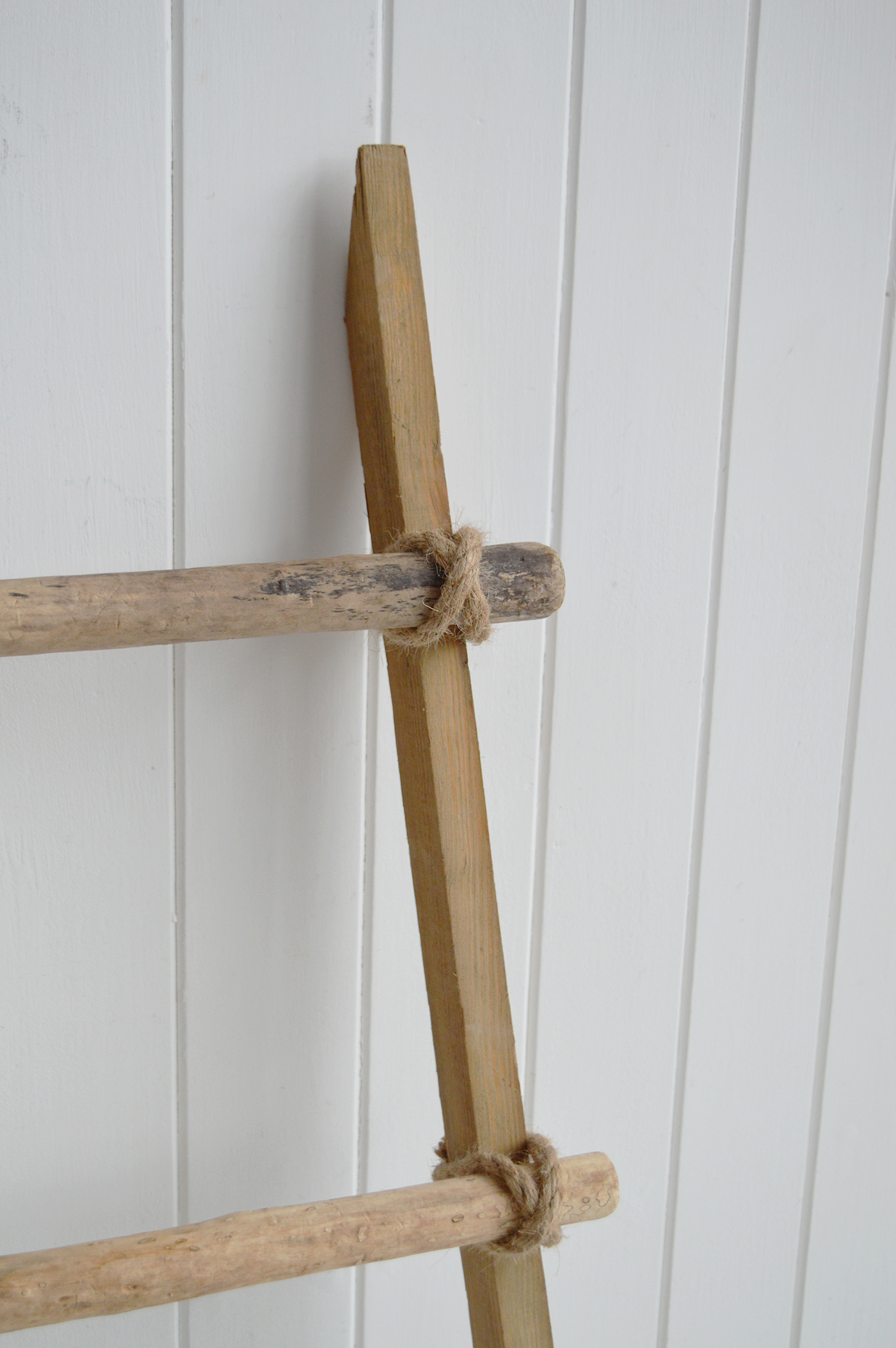 Drape a soft throw over the wooden rungs for a relaxed beach house look.