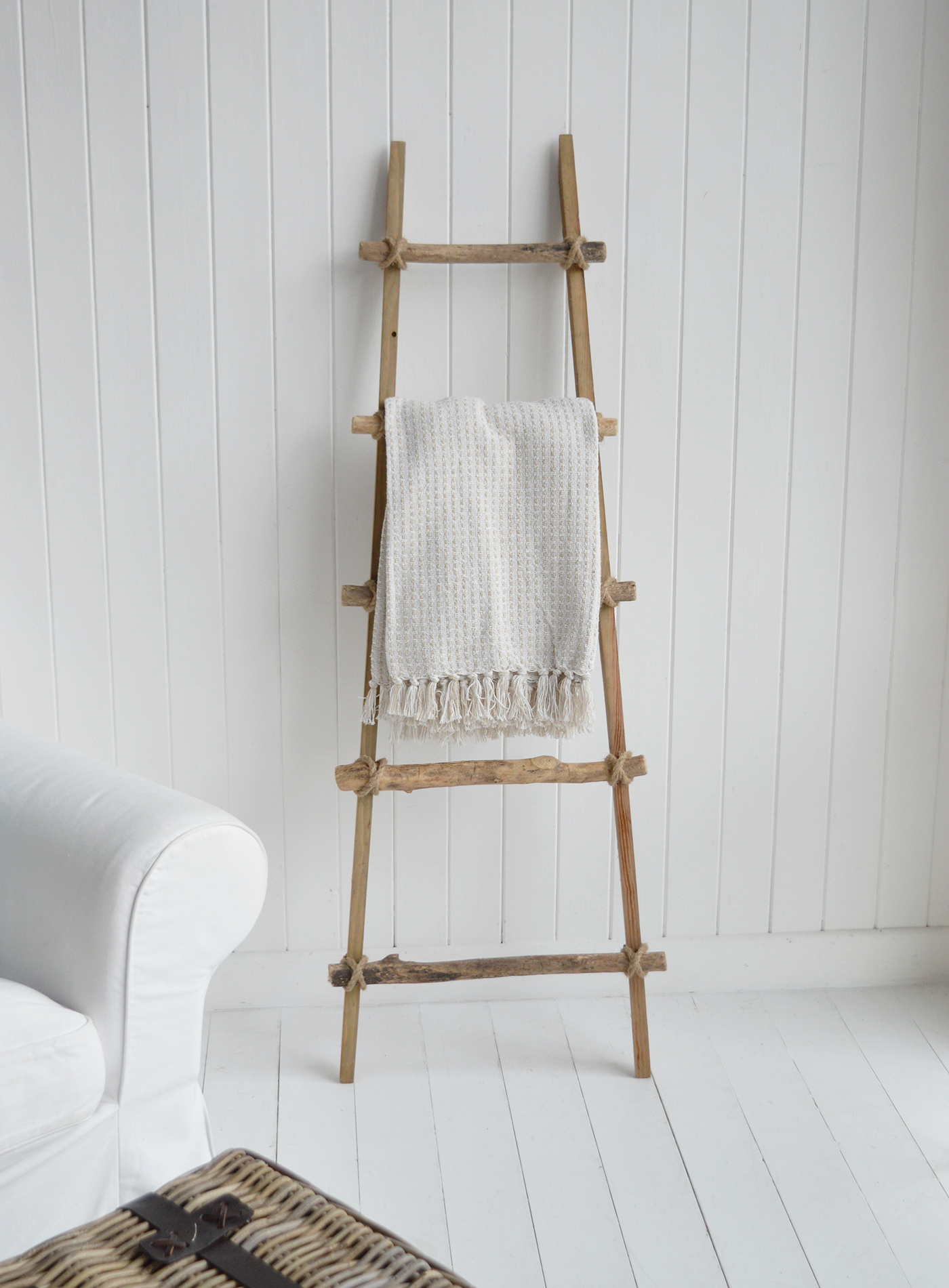 The weathered wood and rope ties sit beautifully alongside white furniture and woven baskets.