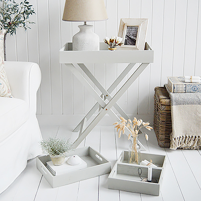 Elegant New England Coastal and Country Furniture. Finished in an aged grey paint with distressing, the Fairfax table is a butler tray table with three insert trays that can be used throughout the home for display