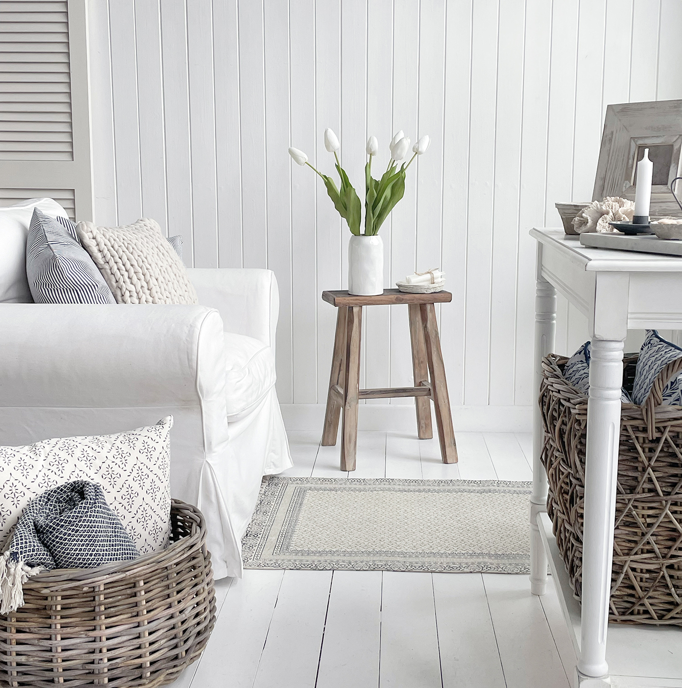 New England living room furniture and home interiors. baskets, cushions, throws, artificial white tulips to create a beautiful relaxed but sophisticated area