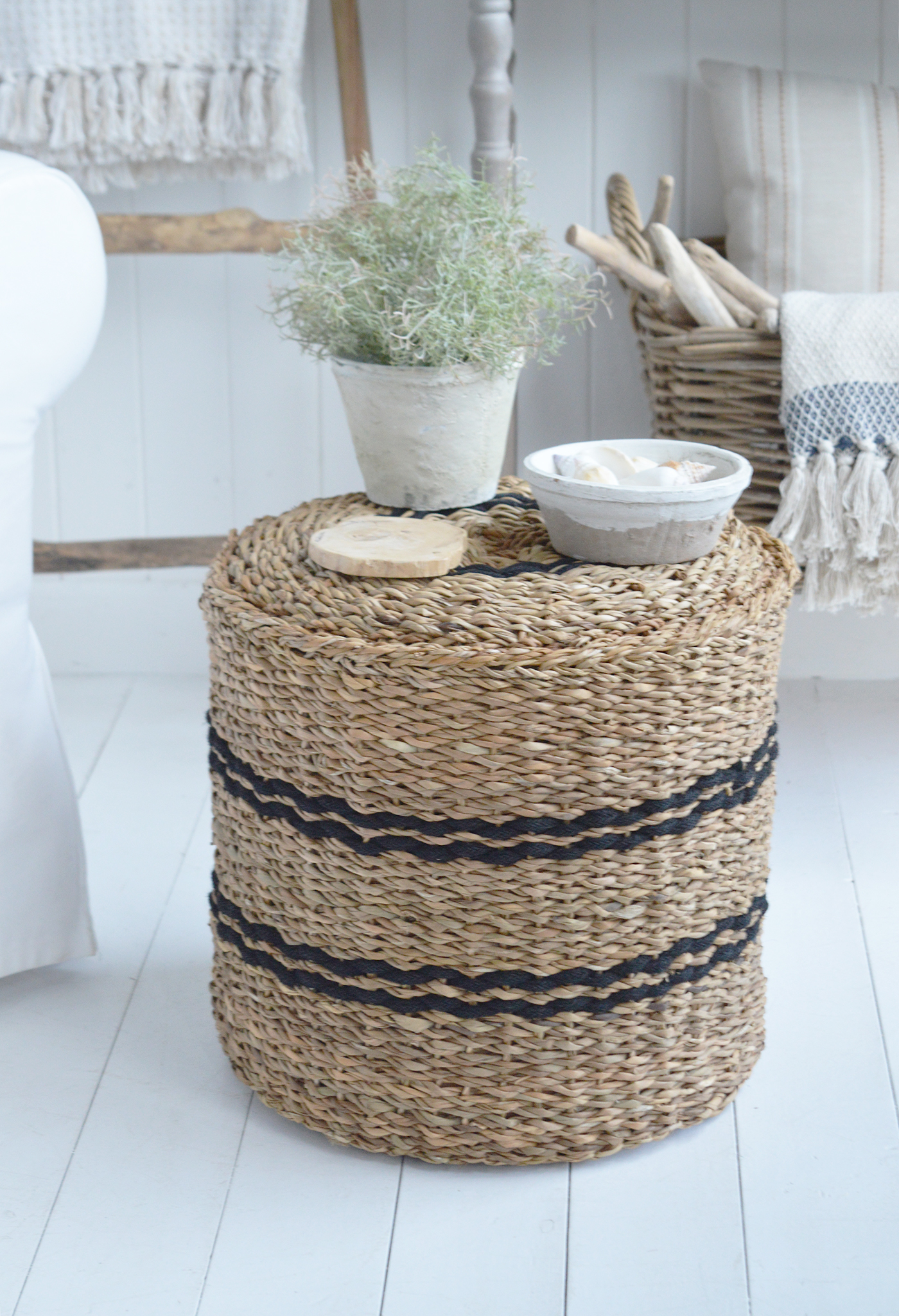Use this soft filled pouffe as a comfortable footstool beside a sofa or armchair in a coastal living room.