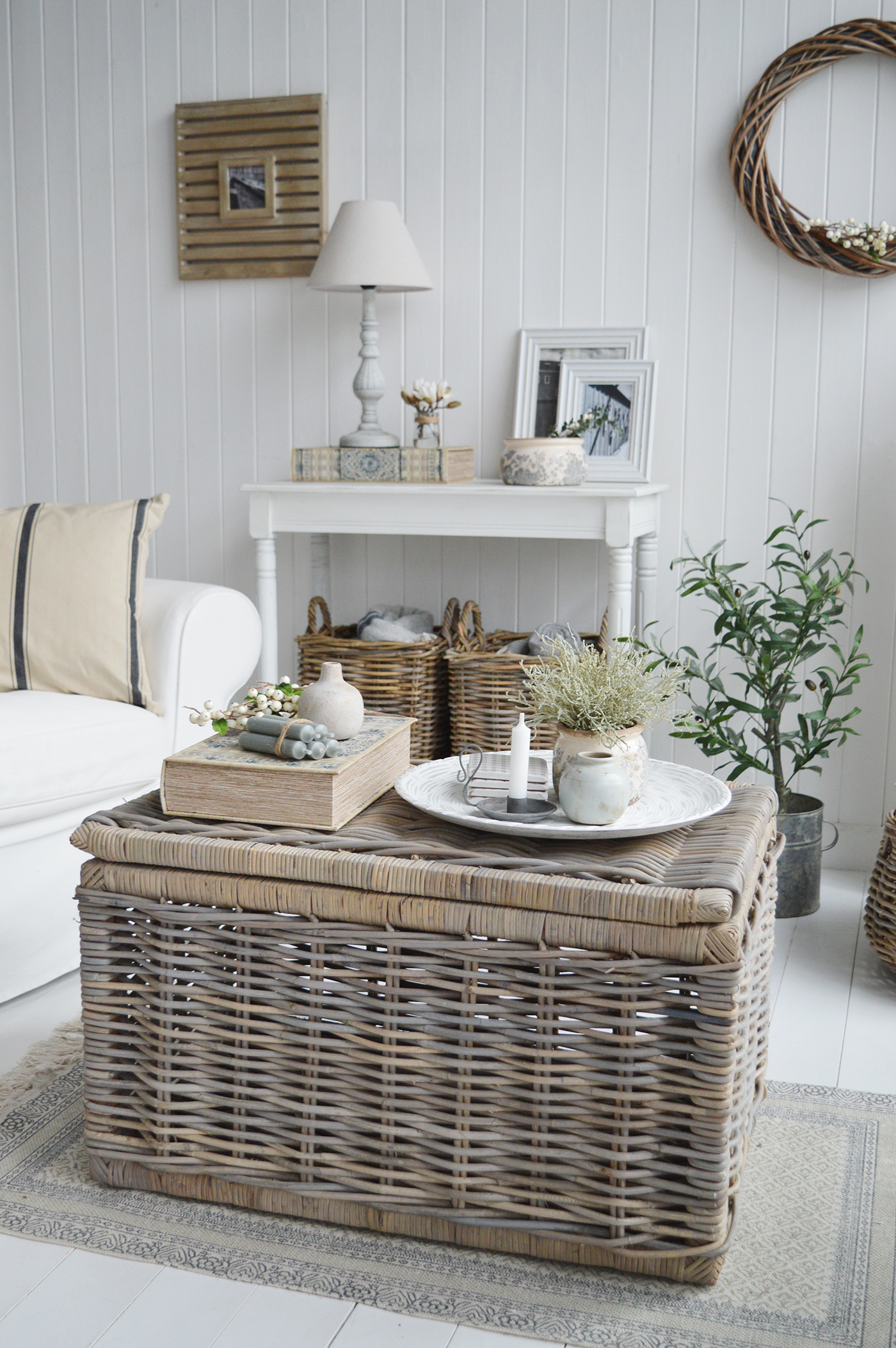 A living room in traditional new England styled interiors for modern farmhouse country and coastal homes. Furniture for the living room inluding coffee tables, white console table and home decor accessories.