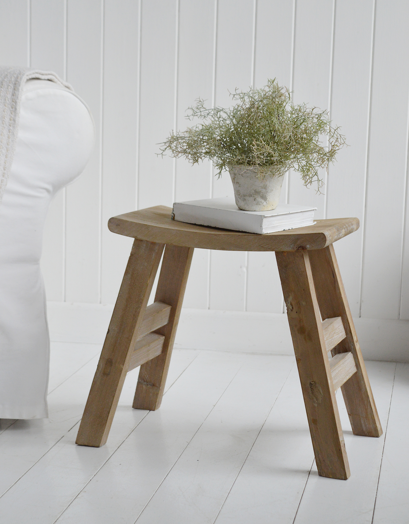 Rustic Pawtucket wooden stool table styled in Hamptons coastal living room with white panel walls