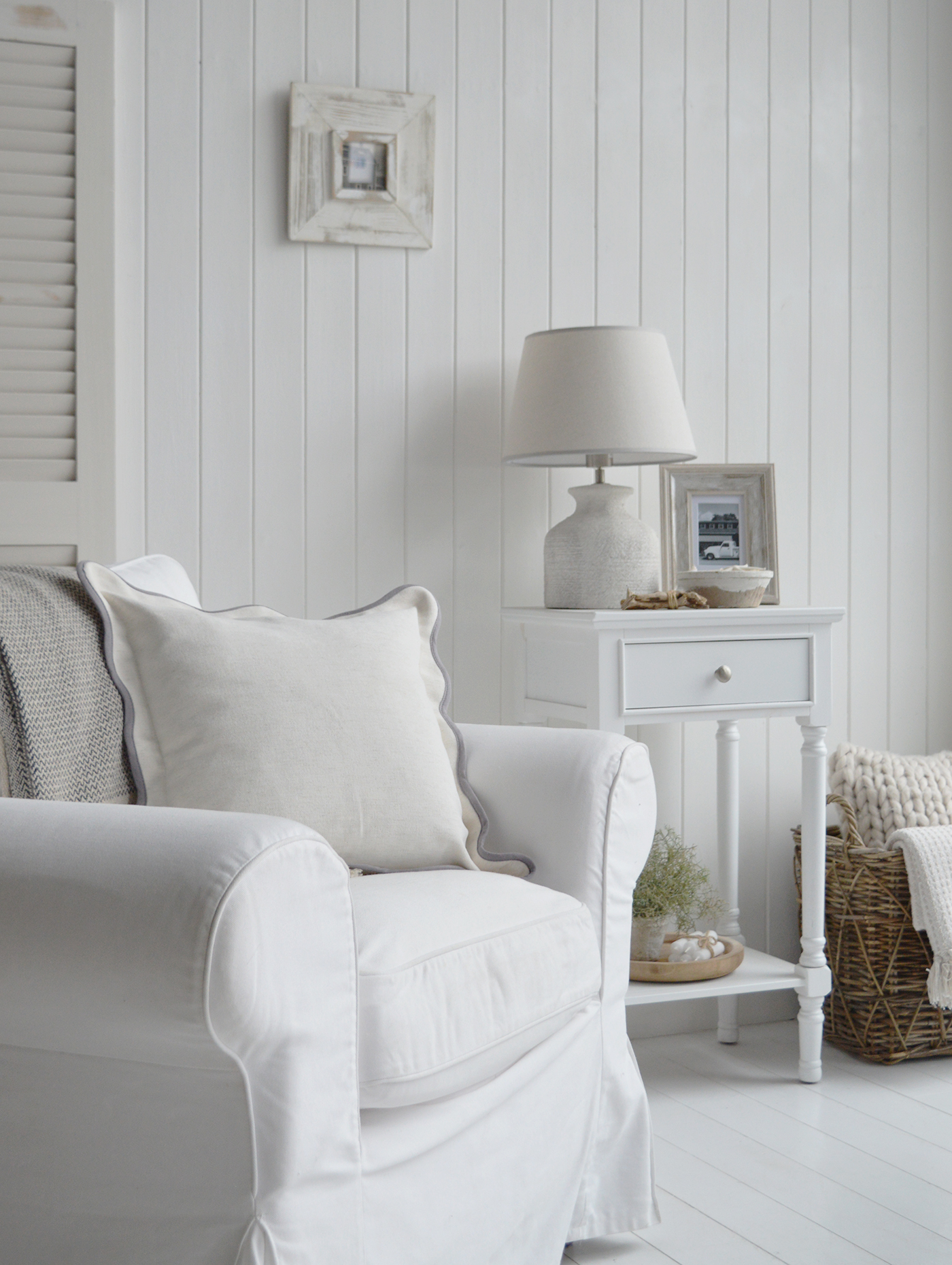 Neutral coastal interior featuring a white lamp table in a relaxed beach house settin