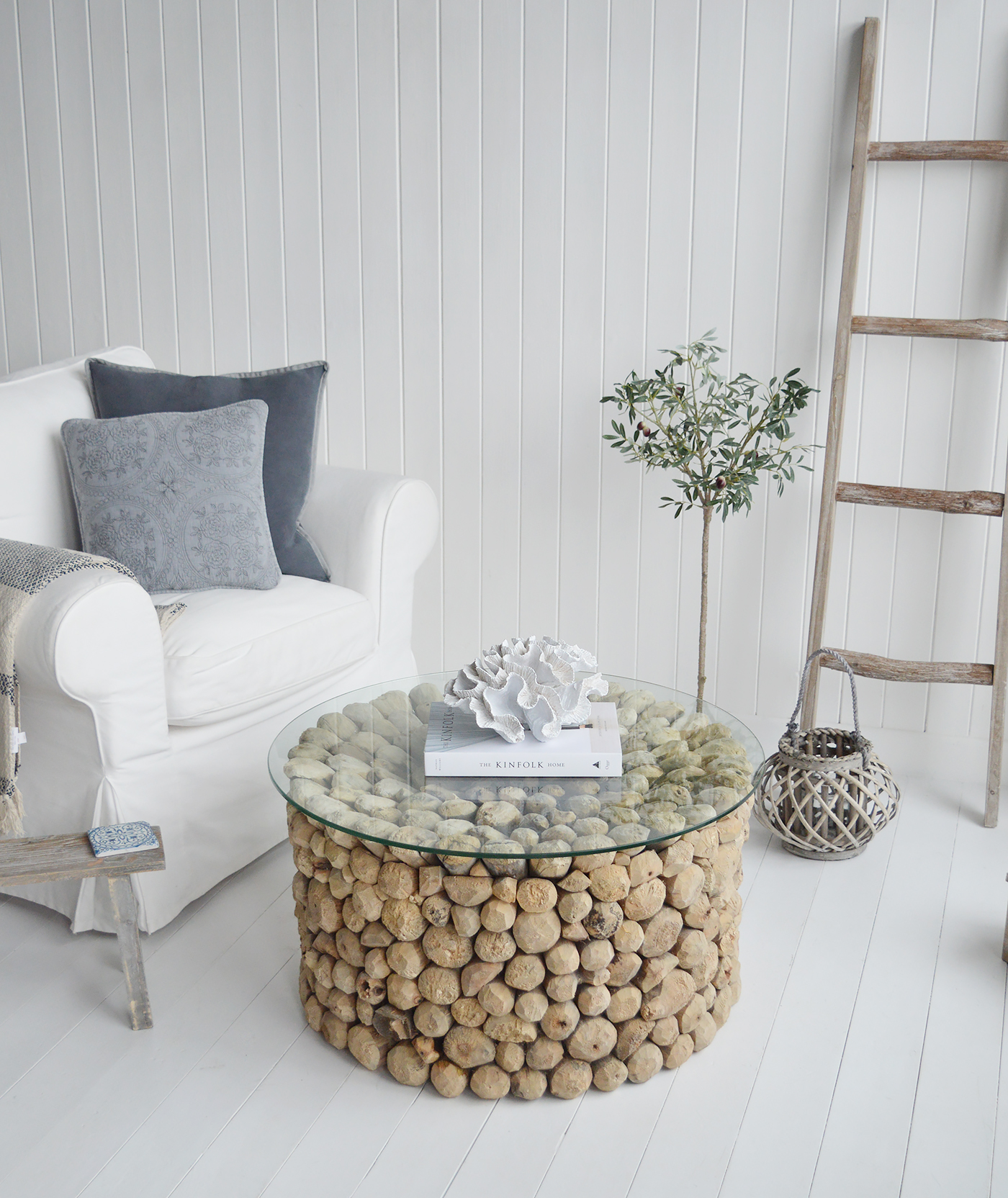 The Sag Harbor driftwood coffee table in a coastal living room, complemented with the driftwood blanket ladder and a piece of faux coral for chic Hamptons style interiors for homes by the sea.