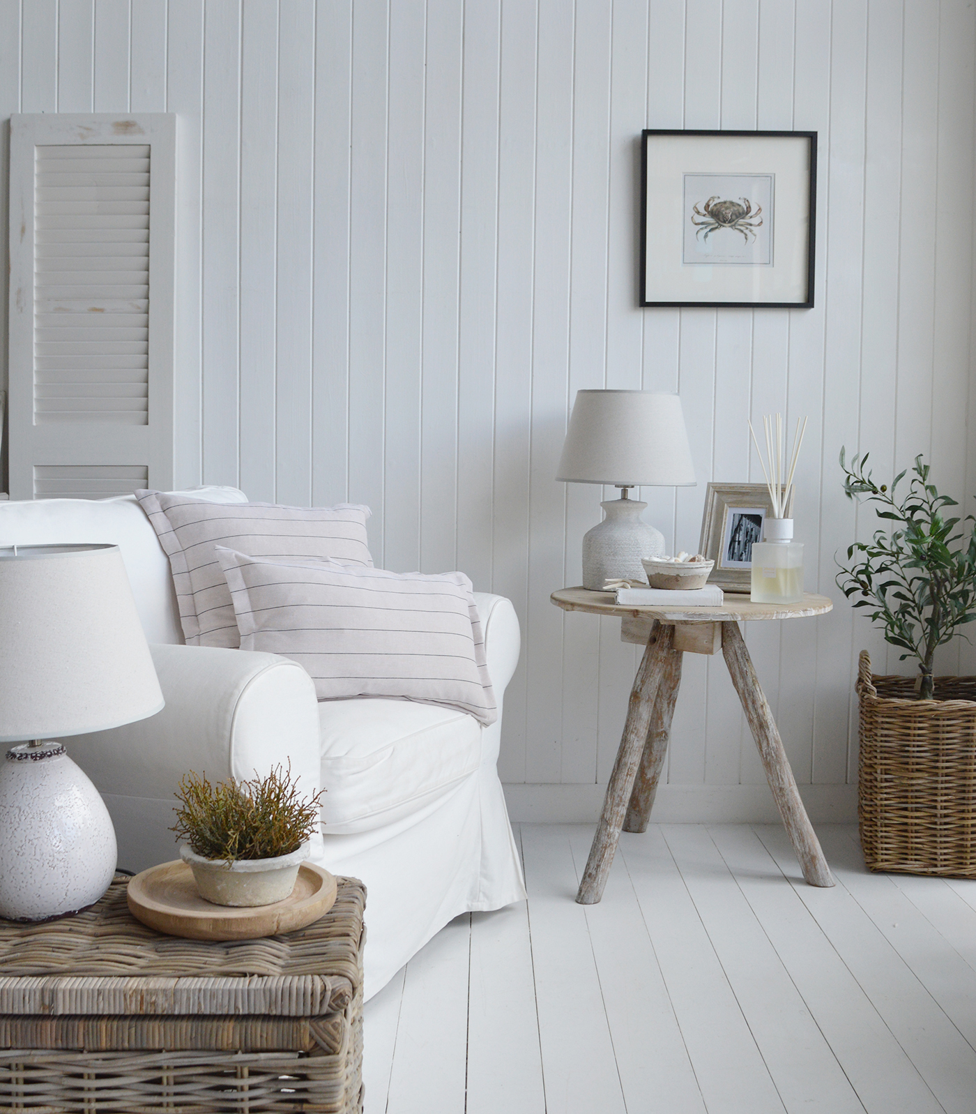 The driftwood table furniture piece styled with photo frames and white diffuser for a Hamptons inspired living room. Shown with natural baskets and greeener for a relaxed feel