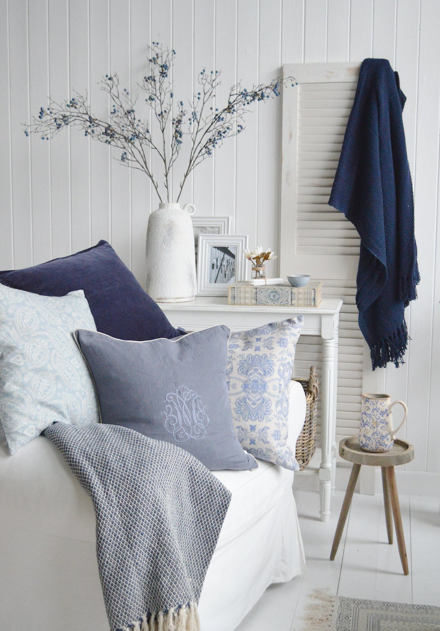 Blue and white living room decorating ideas. White furniture with blue cushions, throws and accessories for coastal, country and modern farmhouse homes and interiors