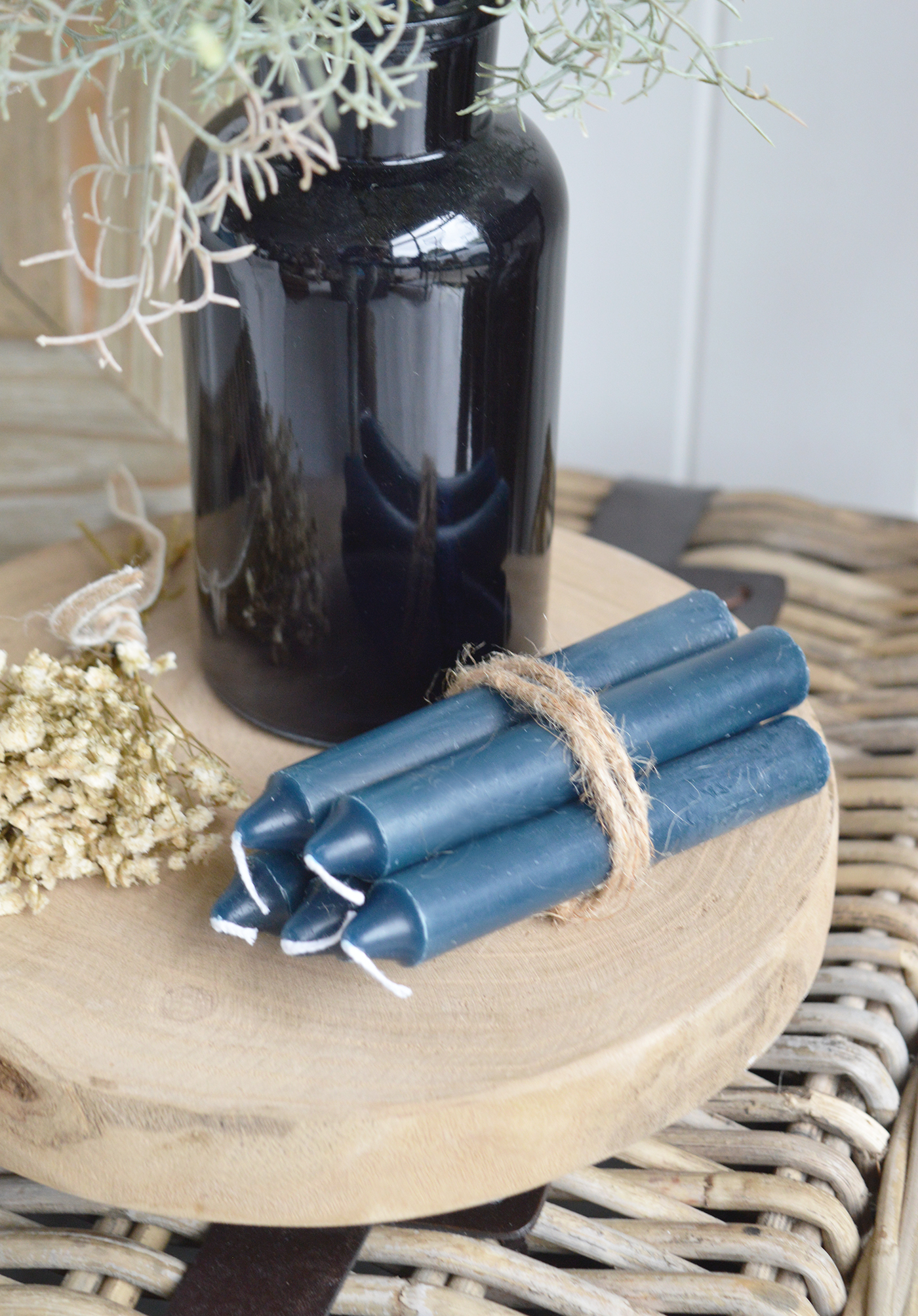 Create a coordinated coastal coffee table display with a blue vase, faux foliage and decorative accessories.