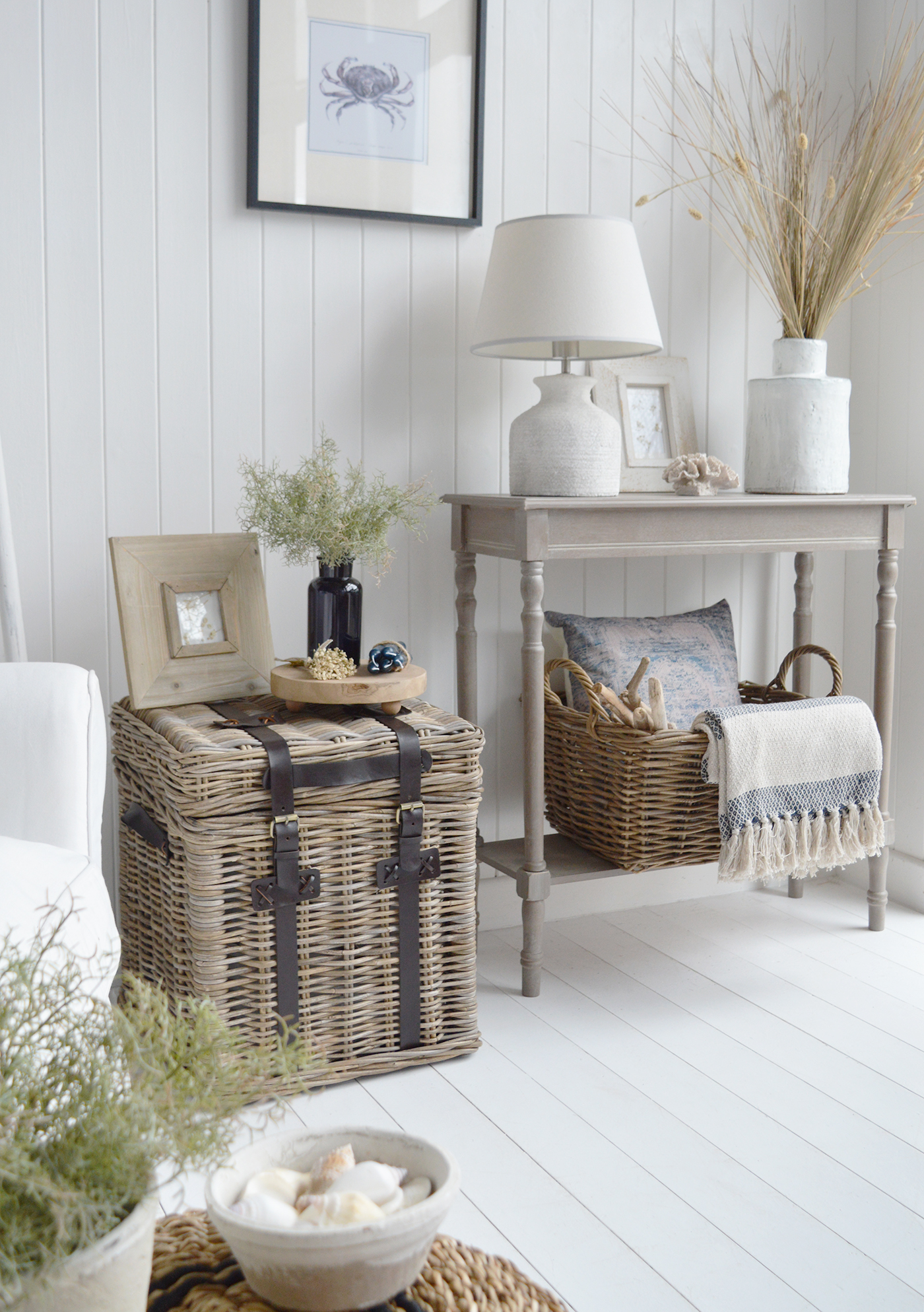 A greywashed console, woven storage baskets and subtle blue accents bring warmth and practical style to a modern coastal living room.