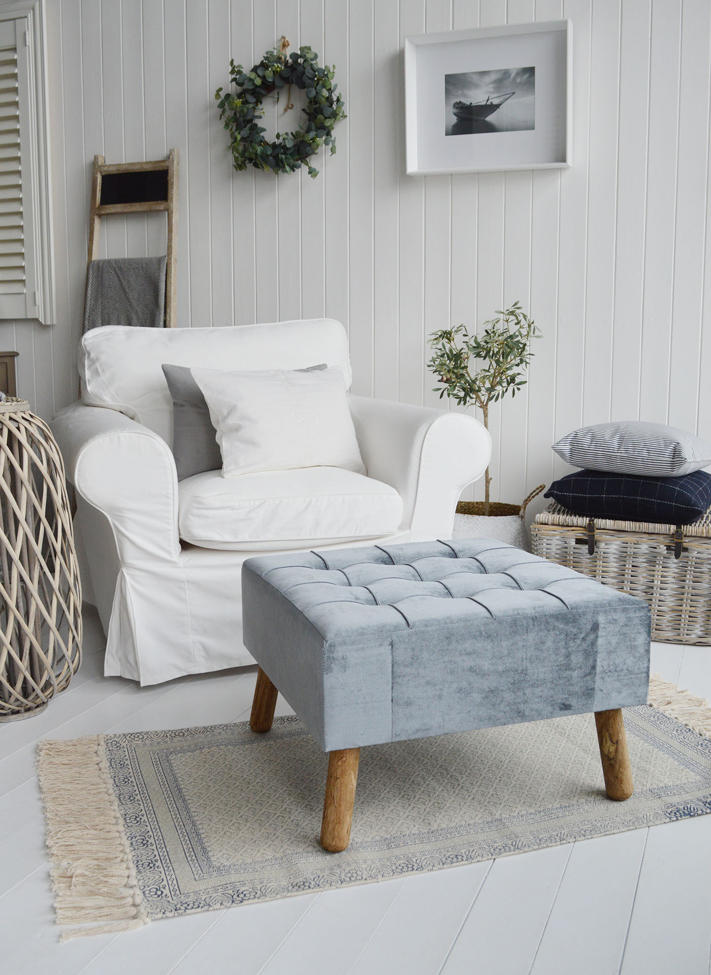 The New London footstool and ottoman in a buttoned luxurious blue grey velvet with aged oak coloured legs.A beautiful classic, timeless addition for all New England style homes in the country, by the coast and in the city