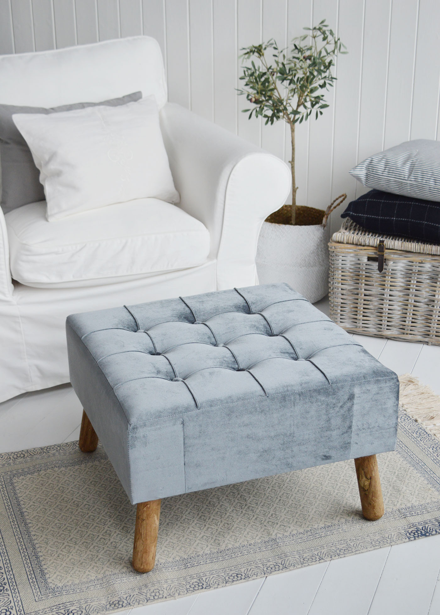 The New London footstool and ottoman in a buttoned luxurious blue grey velvet with aged oak coloured legs.A beautiful classic, timeless addition for all New England style homes in the country, by the coast and in the city