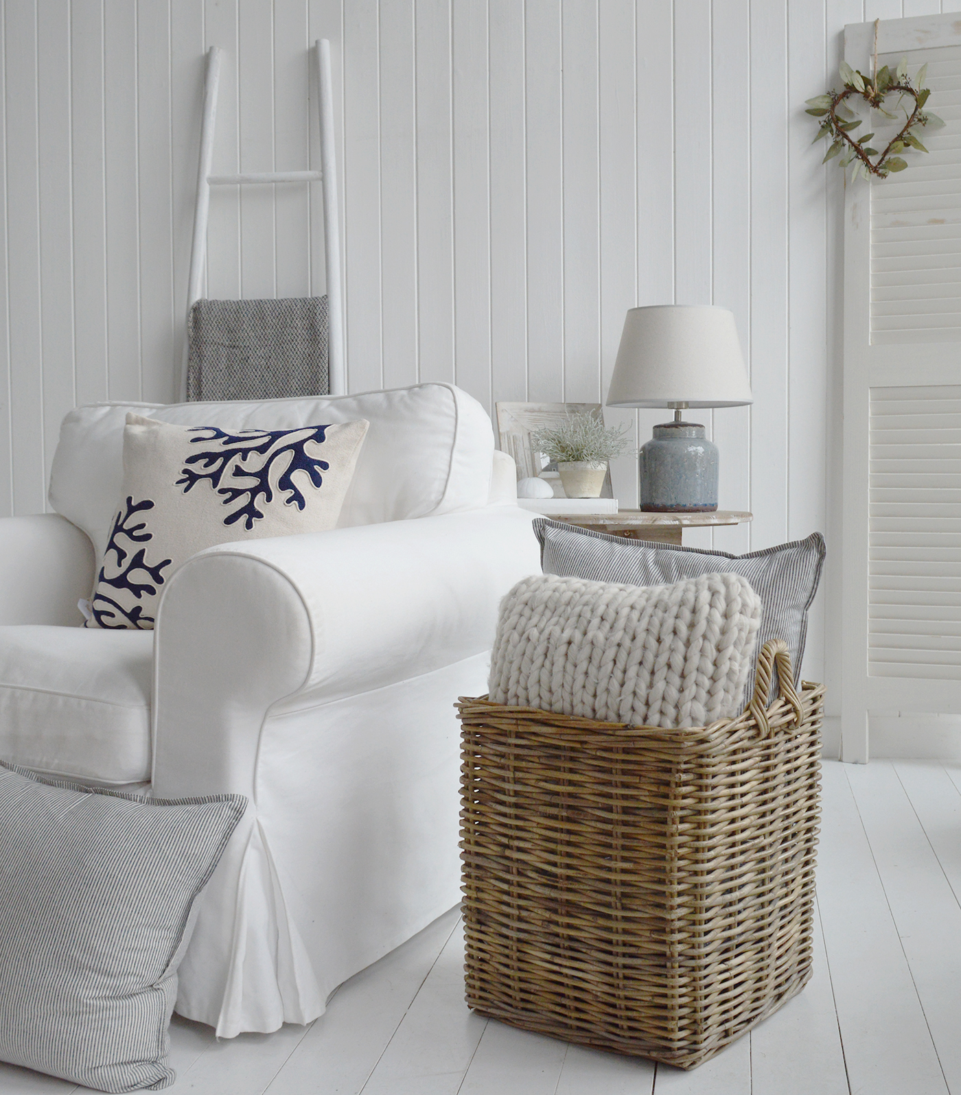 A Hamptons style living room in white with textural accessories for a relaxed space ... the Casco Bay basket filled with cushions, driftwood table and white Provincetown blanket ladder 