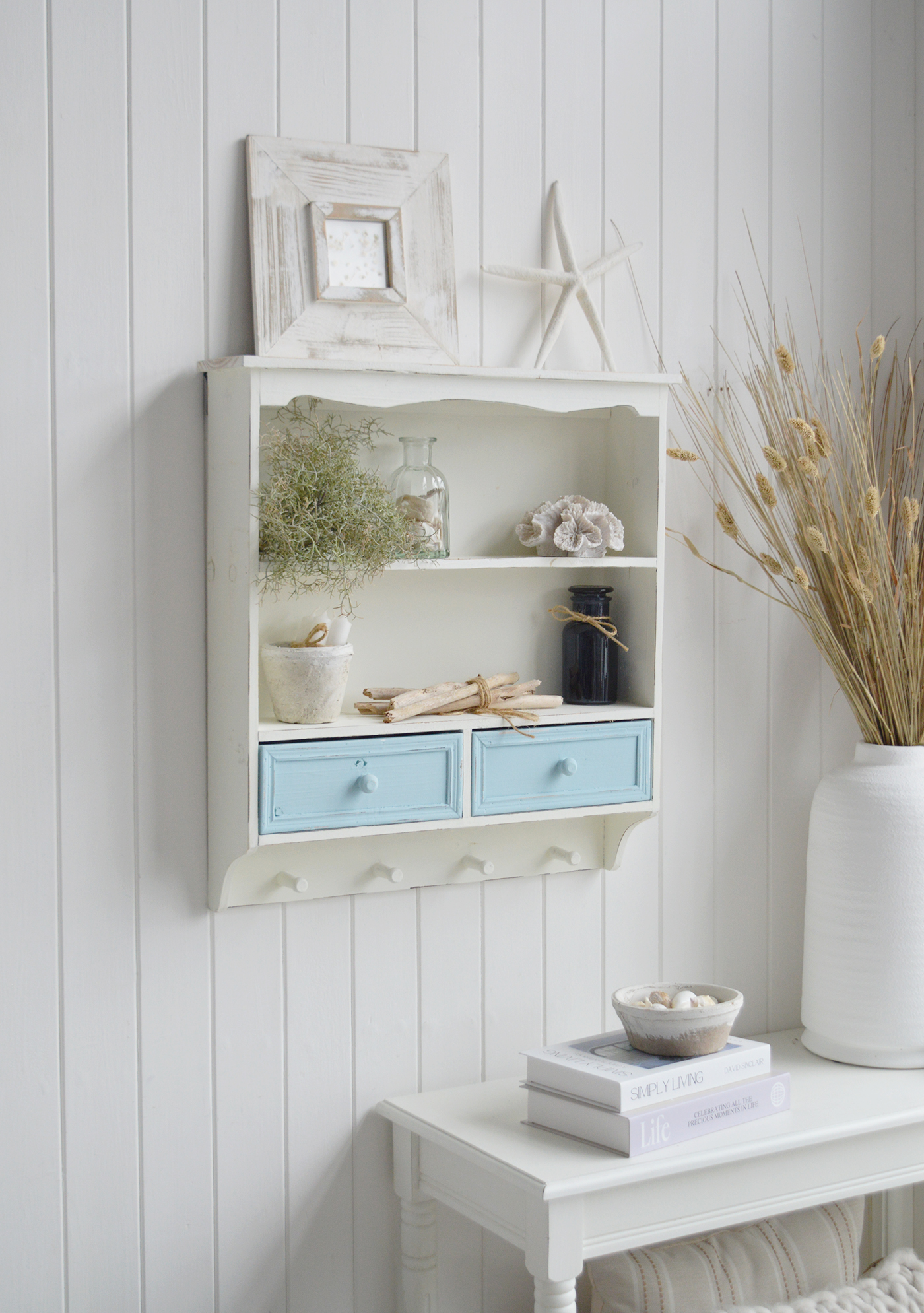 The Woodstock Wall Shelf Unit combines rustic white shelving with pale blue drawers for a fresh New England-inspired look.
