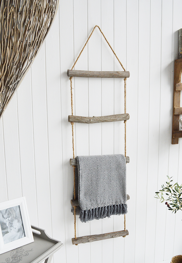 A rope ladder with driftwood effect rungs to hang towels, throws or blankets for a nautical coastal styled living room - blanket ladder. from The White Lighthouse Furniture , New England interiors and furniture for the hallway, living room, bedroom and bathroom