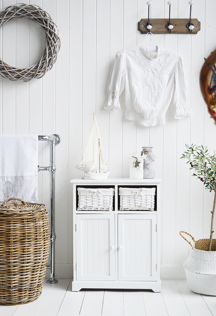 Maine white large bathroom cabinet. Furniture for storage in the bathroom for New England, country, coastal and city home interiors. Photogrpah for ideas in decorating a white bathroom