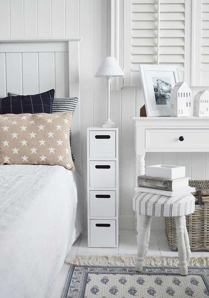 A very narrow white bedside table from the Dorset Range with four drawers    Ideal for when space is tight, At only 17cm for the max width, the Dorset slim range offers storage for narrow spaces, with four drawers.    "Perfect for max width of 20cm"    With a white satin painted finish, handless drawers, straight lines and New England style cladding on top, sides and drawers , this simple unit is perfect for any room in your home whether you are in the country, by the coast or in the city