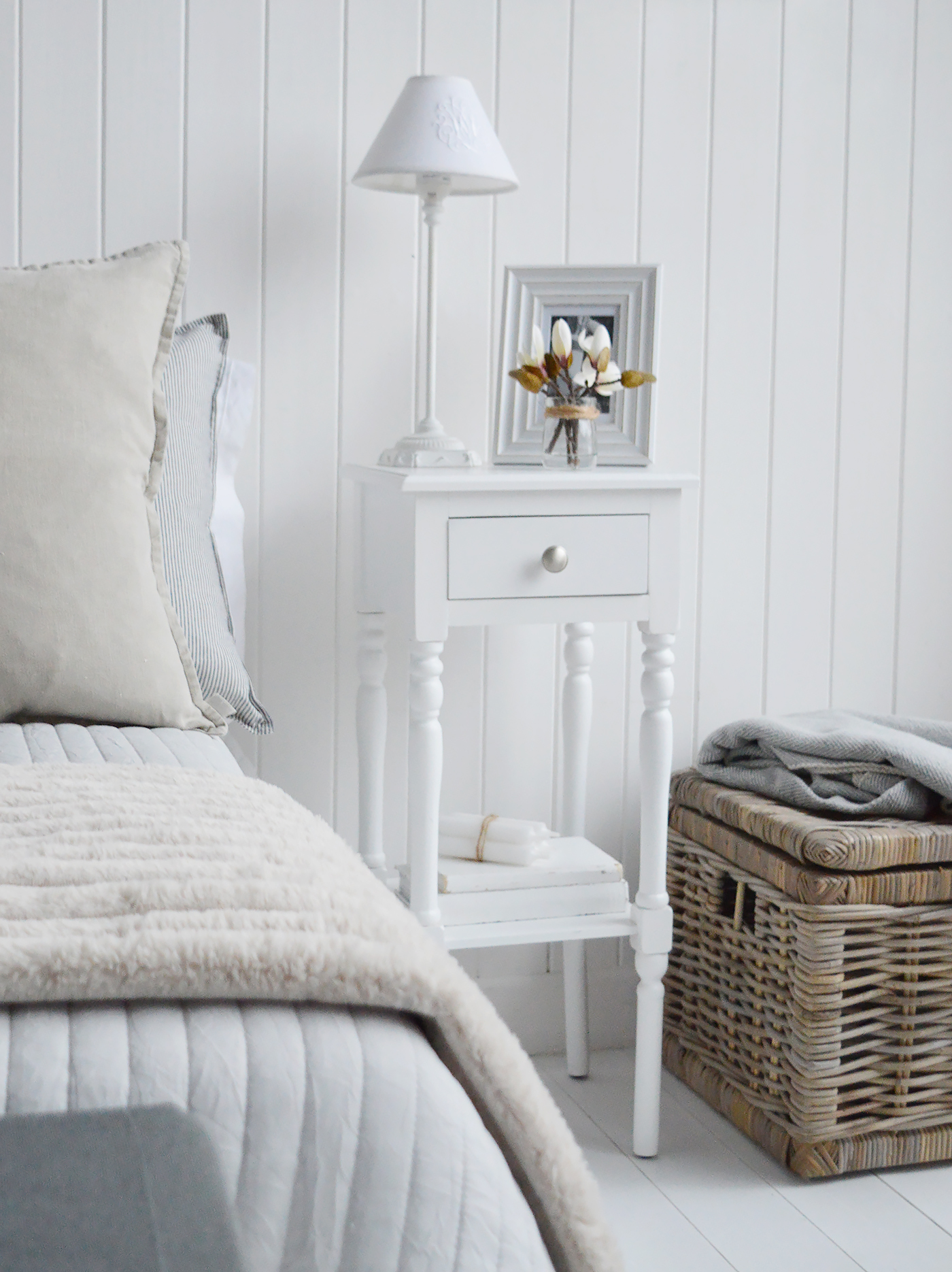 The Georgetown white narrow bedside table with a drawer and shel in a white bedroom