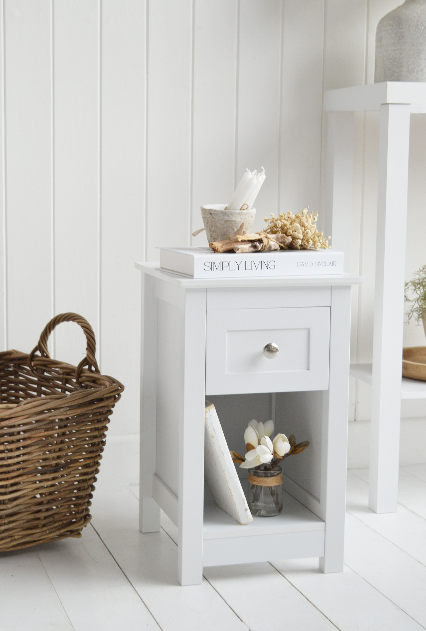 This classic slim white bedside table with drawer and shelf adds practical storage to coastal and Hamptons inspired homes.