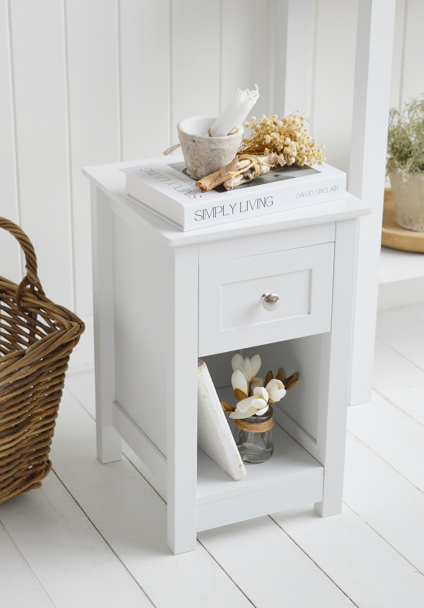 A timeless choice for coastal interiors, this slim white bedside table blends clean lines with traditional detailing.